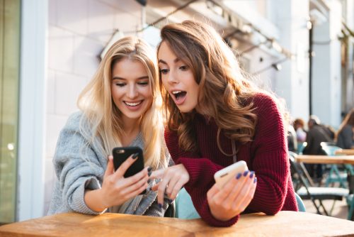 スマホを見て驚く女性