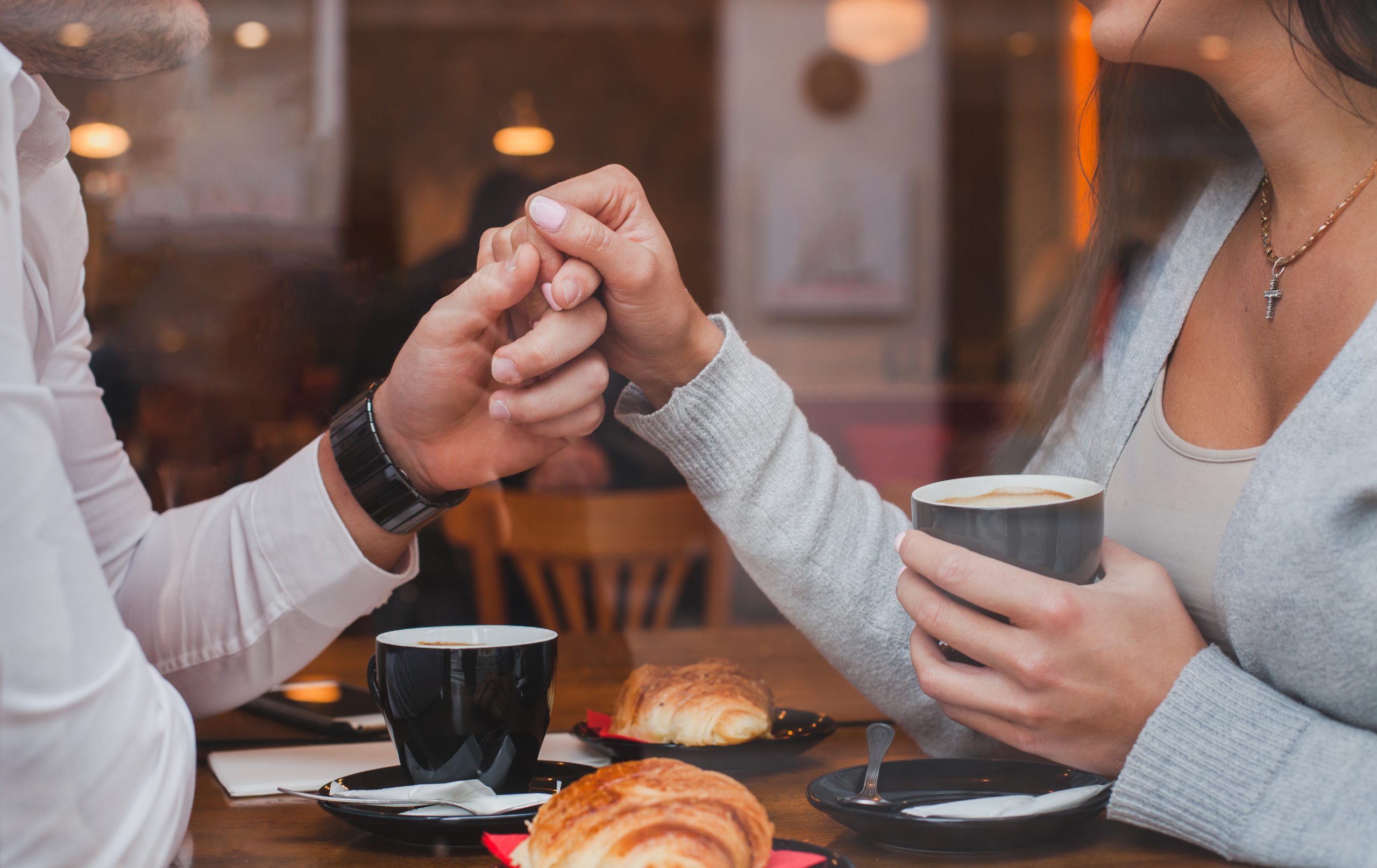カフェで手を握る男女