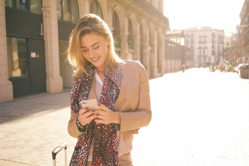 街角でスマホを持つ女性