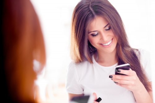 笑顔でスマホを見る女性