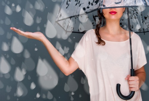 Portrait of beautiful young fashionable woman standing under umb