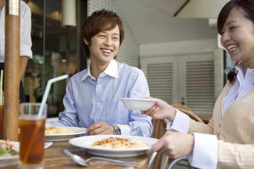smiling couple sitting on cafe terrace