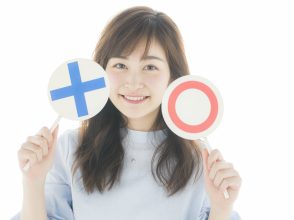 マルバツの札を持った女性