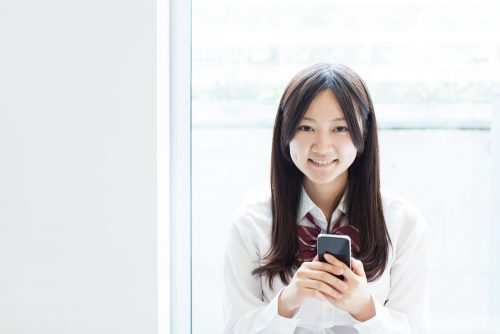 スマホをもつ女子高生