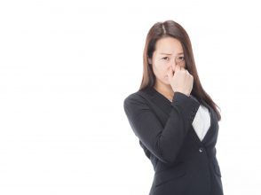 鼻をつまむ女性