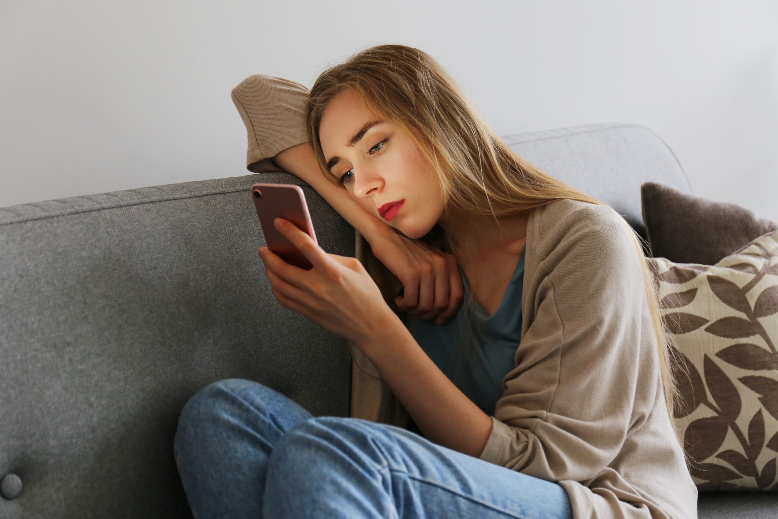 暗い表情でスマホを見る女性