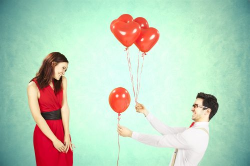 風船を持って女性にアプローチする男性