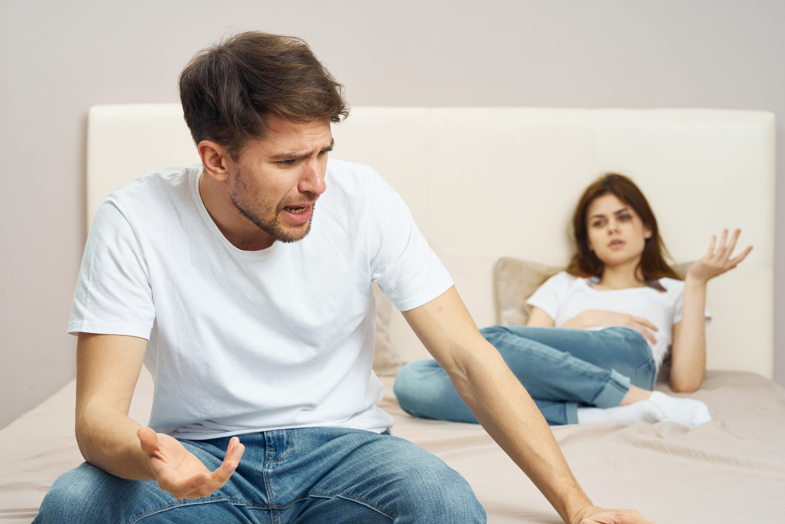 ベッドに腰掛けて怒る男性