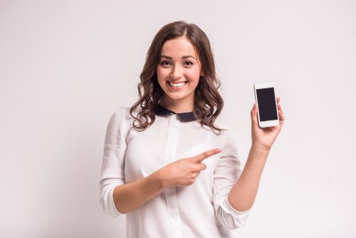 スマホを指差す笑顔の女性