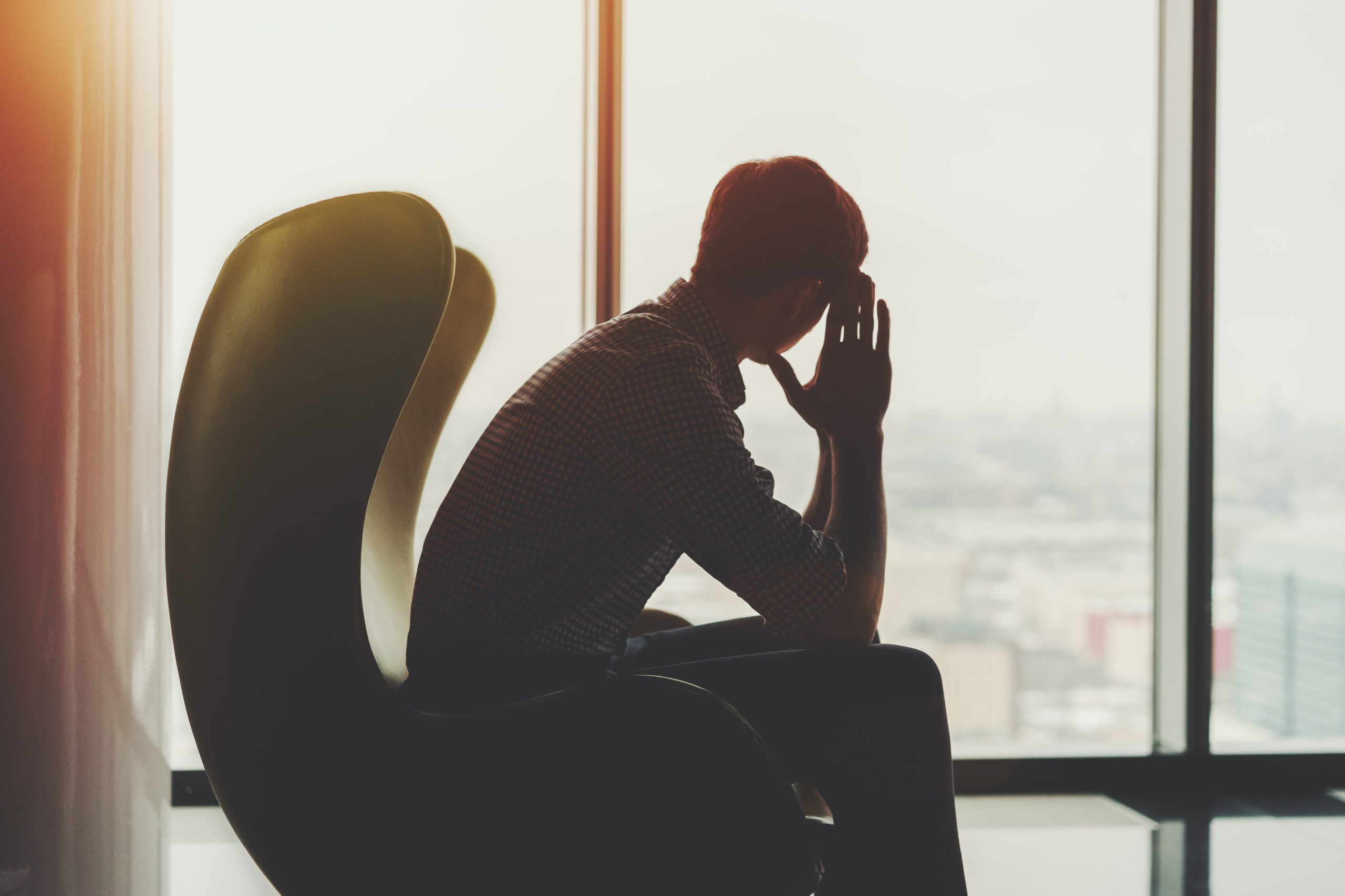 窓辺で考え込む男性