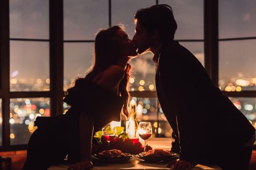 夜景が美しい場所でキスをする男女