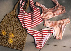 右から、オレンジ色の縦ストライプビキニ、赤色の横ストライプビキニ、茶色のあみあみバッグ