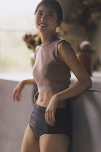 ピンクブラウンのニットトップスに、グレーのボトムスを合わせた水着。へそ出しスタイル。