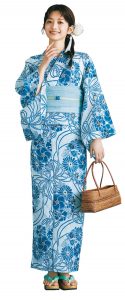 水色の生地に、ブルーの大きな花柄が描かれている浴衣を着たモデルの全身写真。手にはかごバッグを持っており、草履の鼻緒はエメラルドクリーンに近い色。